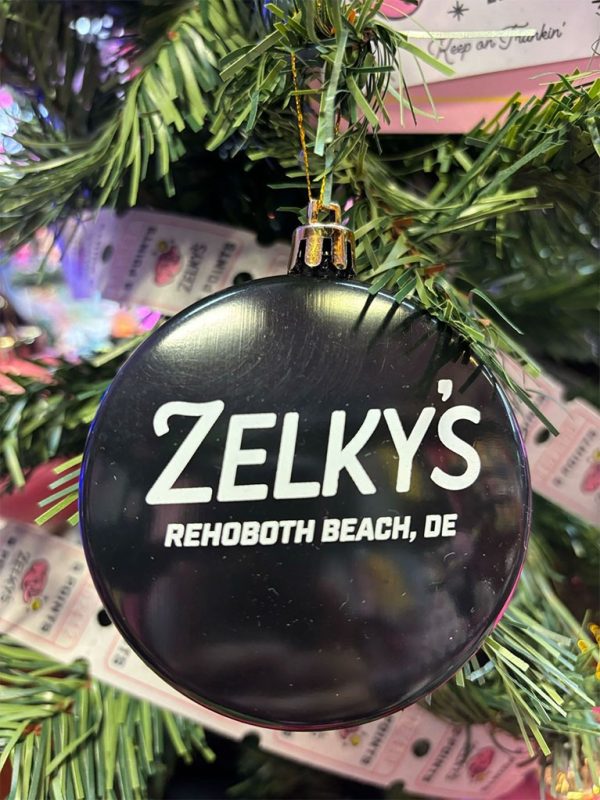 A christmas ornament hanging from the side of a tree.