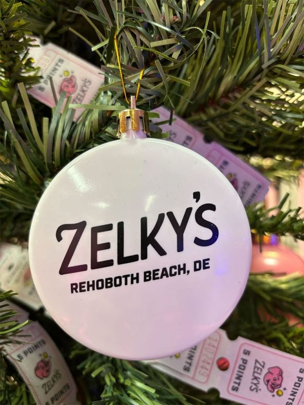 A white ornament with the name of zelky 's in black lettering.