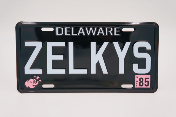 A black and white license plate with the name of zelkys