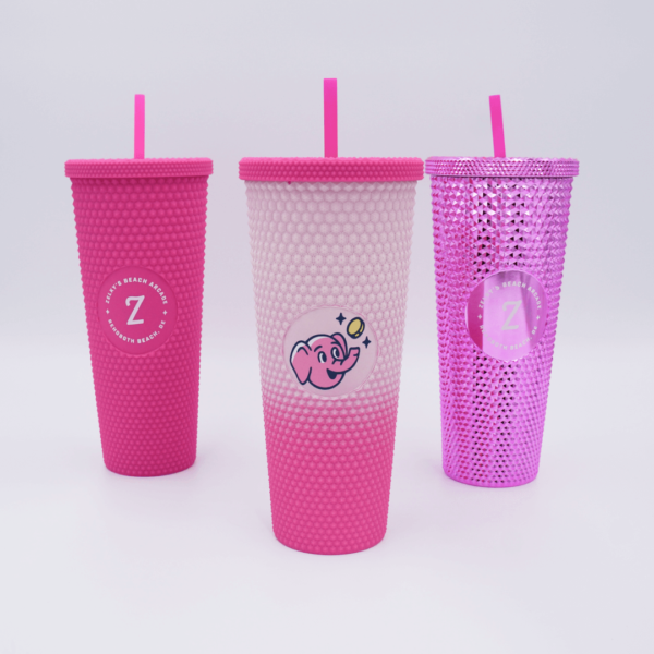 Three cups with straws are sitting on a table.